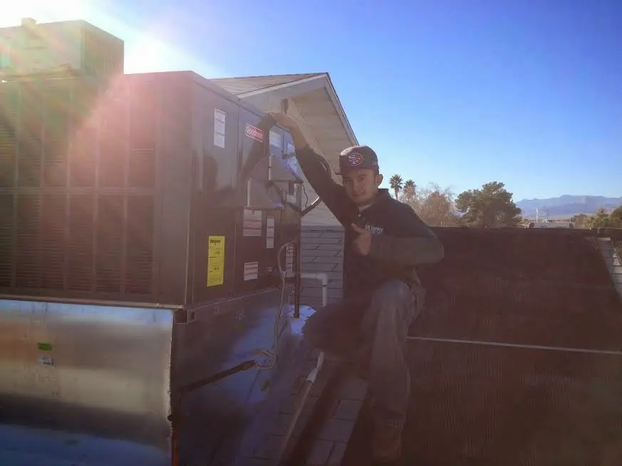 HVAC technician performing Boiler Repair on a rooftop unit in Wellington