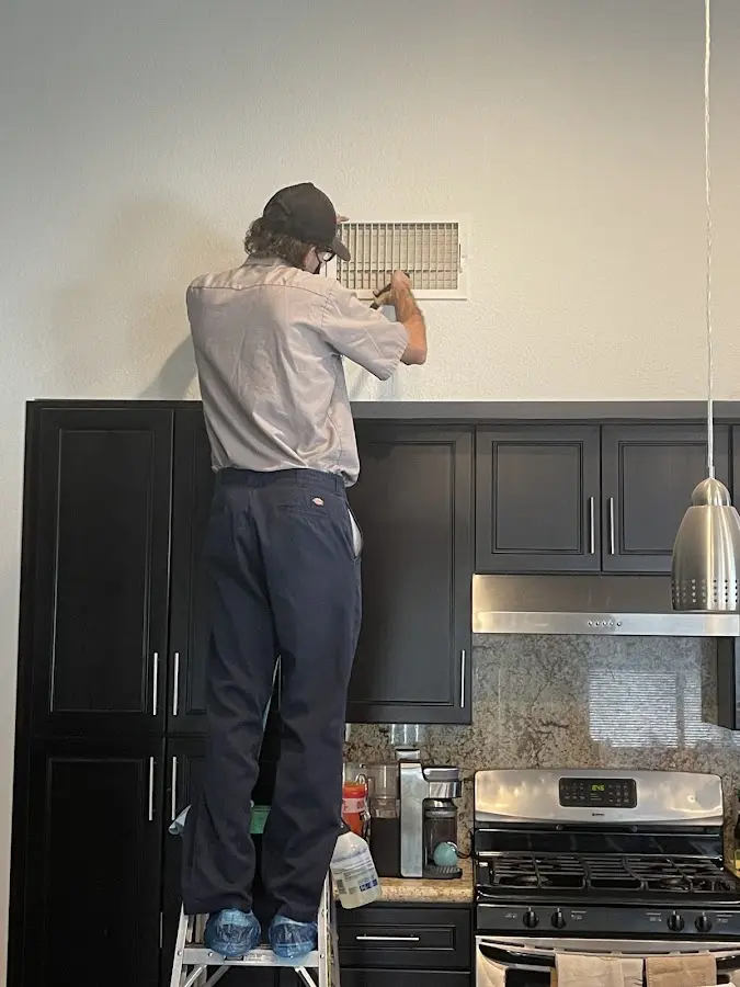 Technician inspecting an air vent during HVAC service in Wellington